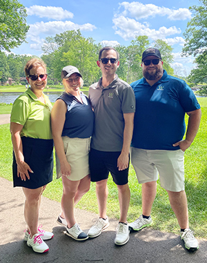 Welsh and Associates enjoy a beautiful sunny day with puffy clouds in the blue sky on the golf course.